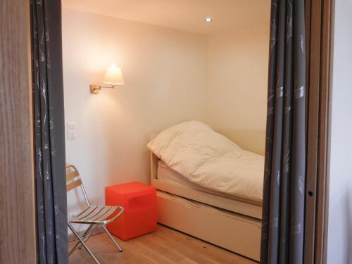 um pequeno quarto com uma cama e uma cadeira em Appartement Le Palais, 2 pièces, 6 personnes - FR-1-418-177 em Le Palais