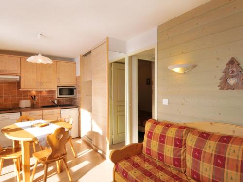 Il dispose d'une cuisine et d'un salon avec un canapé et une table. dans l'établissement Appartement rénové skis aux pieds avec balcon - FR-1-181-2050, à La Plagne Tarentaise