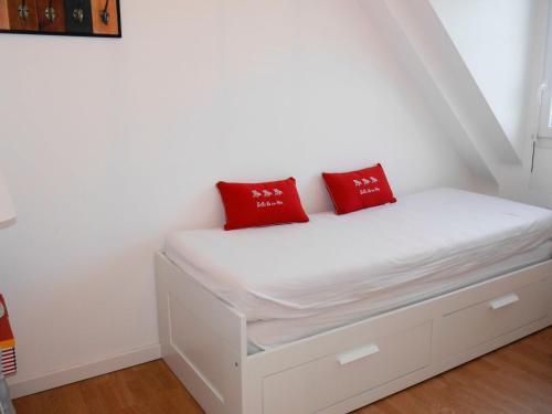- un lit blanc avec 2 oreillers rouges dans l'établissement Maison neuve avec jardin proche centre et plage, 2 chambres, terrasse et parking - FR-1-418-220, au Palais