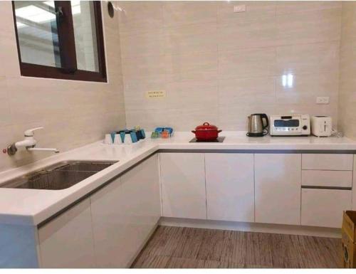 a kitchen with white cabinets and a sink at Han's inn in Magong