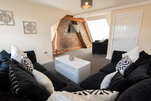 a living room with a black couch and a white table at Number 46 in Langley Park
