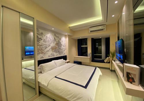a bedroom with a large bed and a television at Luxury Modern La Casa Benson in Lontar