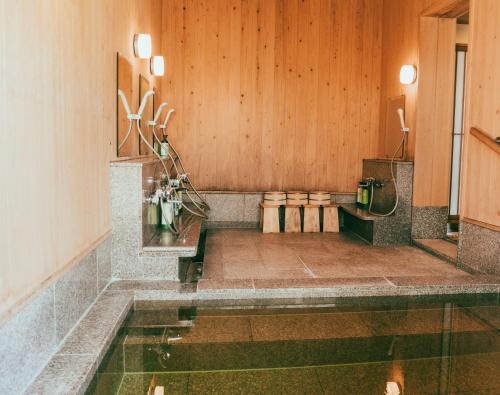 Ein Raum mit einem Wasserbecken und Holzwänden in der Unterkunft Kyufukujyuin Takei Ryokan in Nagano