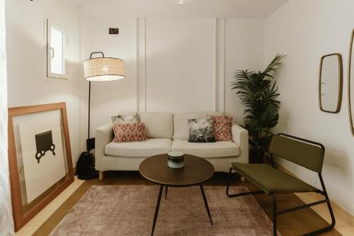 sala de estar con sofá y mesa en Tu casa con piscina privada en el centro, en Sevilla