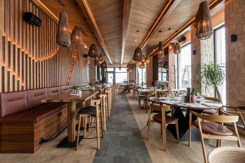 a restaurant with wooden tables and chairs and benches at Aparthotel RAJSKA in Jahorina