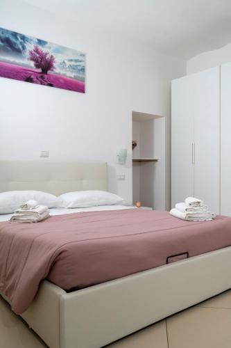 a bedroom with a large bed with a purple blanket at La casa di Thomas in centro in Matera