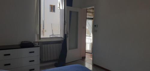 a bedroom with a door leading to a window at Romiti Apartment in Ferrara