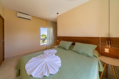 a bedroom with a bed with a flower on it at Reserva Sauípe - Casa 189 in Costa do Sauipe