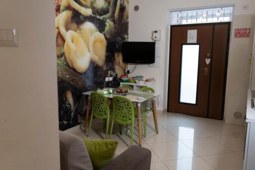 a dining room with a table and green chairs at La casa di Thomas in centro in Matera