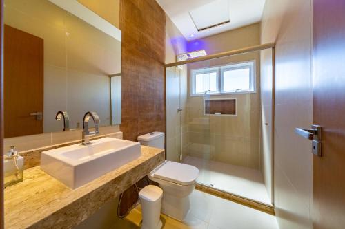 a bathroom with a sink and a toilet and a shower at Reserva Sauípe - Casa 189 in Costa do Sauipe