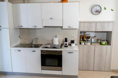 a kitchen with white cabinets and a sink at La casa di Thomas in centro in Matera