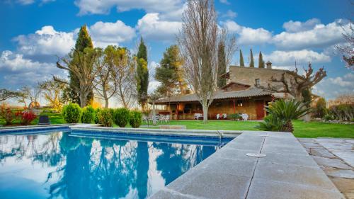 uma casa com piscina em frente a uma casa em Casa Rural Lo molí em Juneda