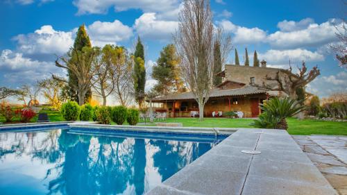 una casa con piscina frente a una casa en Casa Rural Lo molí, en Juneda