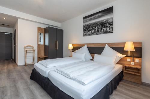 a bedroom with a large bed with white sheets at Hotel in Laisen in Reutlingen