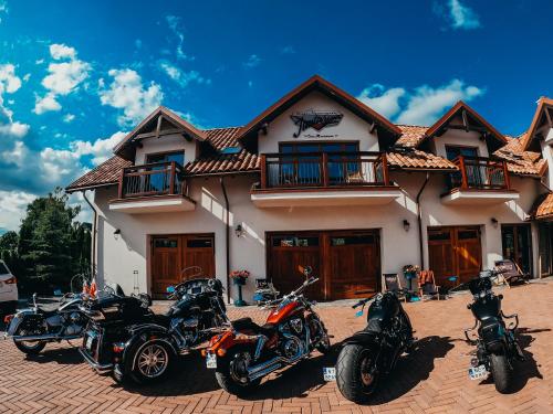 a group of motorcycles parked in front of a house at Jantarvia Car Museum , Pasja i Wypoczynek Noclegi z Klimatem in Jantar