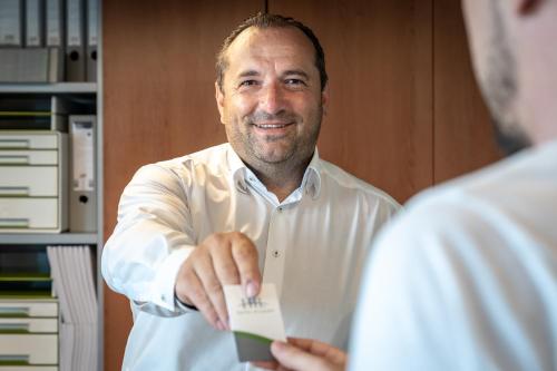 un hombre sosteniendo un pedazo de papel en su mano en Hotel in Laisen en Reutlingen