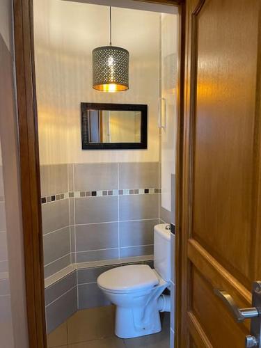 La salle de bains est pourvue de toilettes blanches et d'une lampe. dans l'établissement Résidence Investar appartement 1, à Montluçon