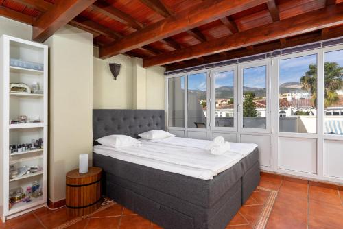 een slaapkamer met een groot bed in een kamer met ramen bij Penthouse with seaview by Costarentals - Ref 08 in Torremolinos