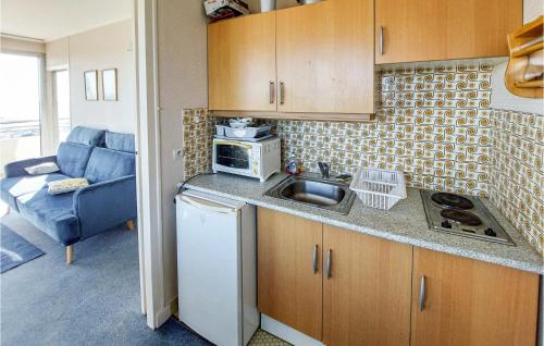 une petite cuisine avec un évier et un micro-ondes dans l'établissement Pet Friendly Apartment In La Baule, à La Baule