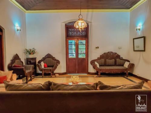 a living room with a couch and chairs at Kithulvilla Holiday Bungalow in Kitulgala