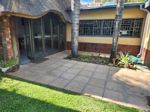 a house with a patio with palm trees in front of it at Be My Guest Too in Upington