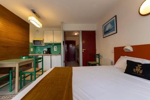 une chambre avec un lit et une table et une cuisine dans l'établissement Mer et Golf, à Anglet