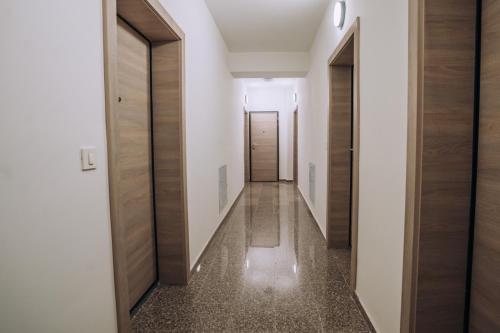 a hallway with white walls and wooden doors at Leon Luxury Apartments in Ohrid