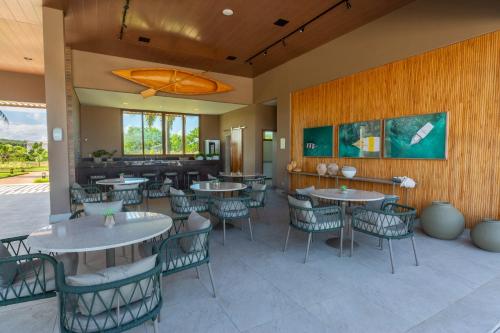 a restaurant with tables and chairs in a room at Reserva Sauípe - Casa 189 in Costa do Sauipe