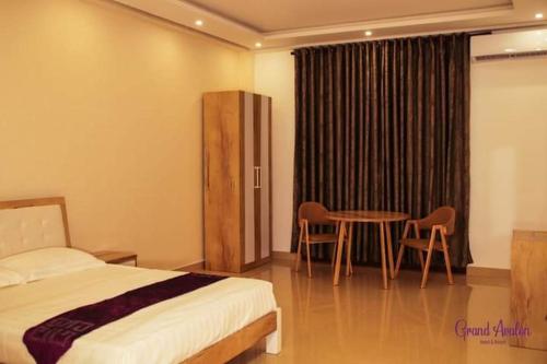a bedroom with a bed and a table and chairs at Grand Avalon in Pothuhera