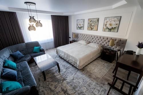 a bedroom with a bed and a couch at Metelitsa Hotel in Karagandy
