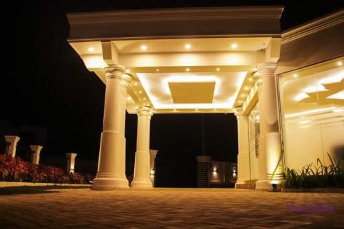 a white building with lights on it at night at Grand Avalon in Pothuhera