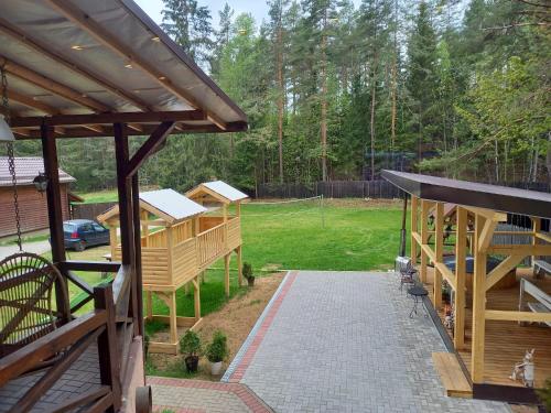 a backyard with a wooden pavilion and a fence at Lesnoj holiday in Vilnius