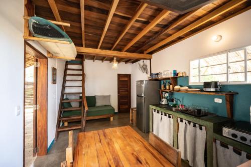 una cocina con techos de madera y una escalera. en TwoTen° Surf Home en Popoyo