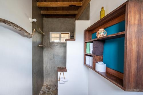 um quarto com uma parede azul e uma porta de madeira em TwoTen° Surf Home em Popoyo