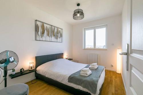 ディジョンにあるLE PANORAMA à deux pas du centre villeのベッドルーム1室(ベッド1台、ファン、窓付)