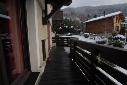 einen Balkon eines Hauses mit Schnee auf dem Boden in der Unterkunft Spacious apartment with garage and balcony overlooking the mountains in Saint-Gervais-les-Bains