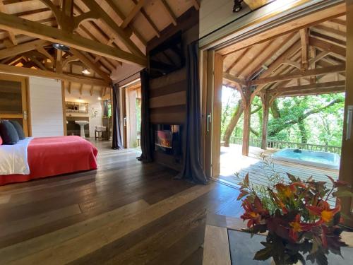 a bedroom with a bed and a fireplace in a house at Châteaux dans les Arbres in Clottes