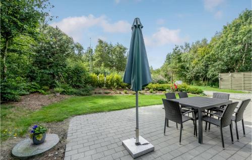 a patio with a table and an umbrella at Holiday Home Alrum Tim Iii in Tim
