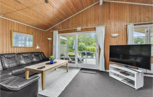 a living room with a couch and a large television at Holiday Home Alrum Tim Iii in Tim