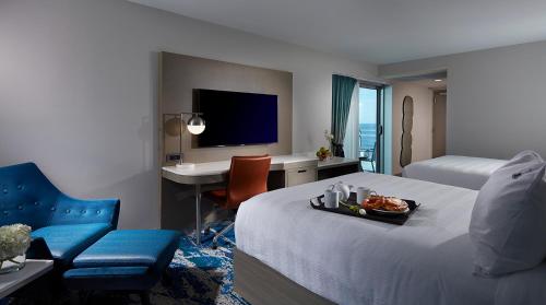 a hotel room with a bed with a tray of food at Hard Rock Hotel Daytona Beach in Daytona Beach