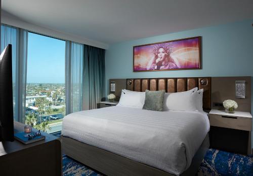 a bedroom with a large bed and a large window at Hard Rock Hotel Daytona Beach in Daytona Beach