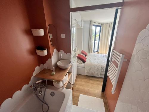 a bathroom with a tub and a sink and a mirror at LA MADELEINE DES GRANDS SABLES 1- 4 PERS in Le Pouldu