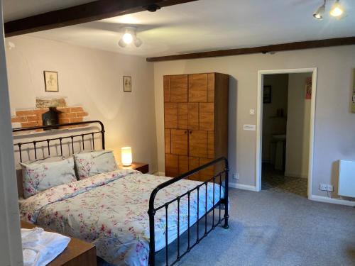 a bedroom with a bed and a dresser at Charming Pretty cottage in Banbury