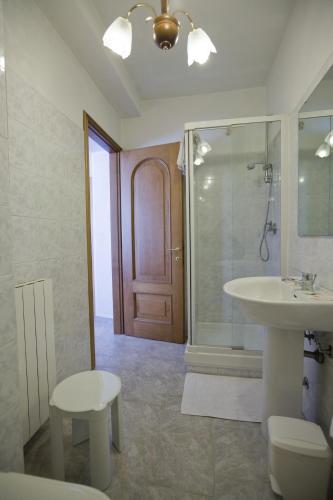 a bathroom with a sink and a toilet and a door at Albergo Ristorante Turchino in Campo Ligure