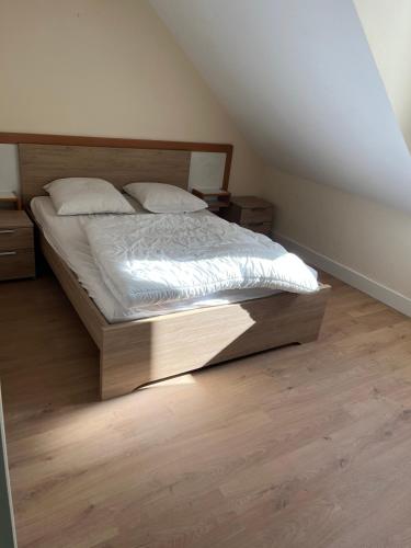 une chambre avec un lit avec une tête de lit en bois dans l'établissement Appartement centre ville Luz Saint Sauveur T4 pour 10 personnes, à Luz-Saint-Sauveur