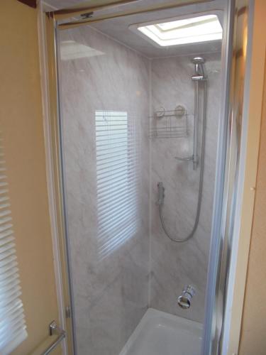a bathroom with a shower with a glass door at 5 Berth on Coral Beach (Granada) in Ingoldmells