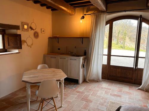 una cucina con tavolo e sedie in una stanza di Villa Convento Pietralunga a Pietralunga