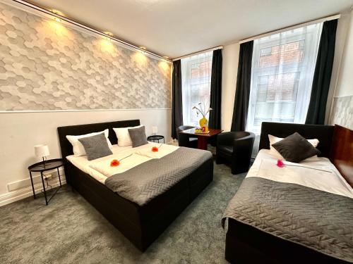 een hotelkamer met 2 bedden en een bureau bij Hotel Nord in Hamburg