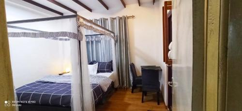 1 dormitorio con cama con dosel y silla en Mount Elegence, en Nuwara Eliya