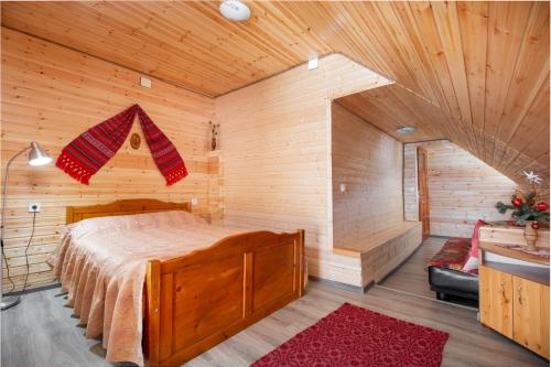 VidraにあるCasa de Vacanta Cascadaの木製の部屋にベッド1台が備わるベッドルーム1室があります。